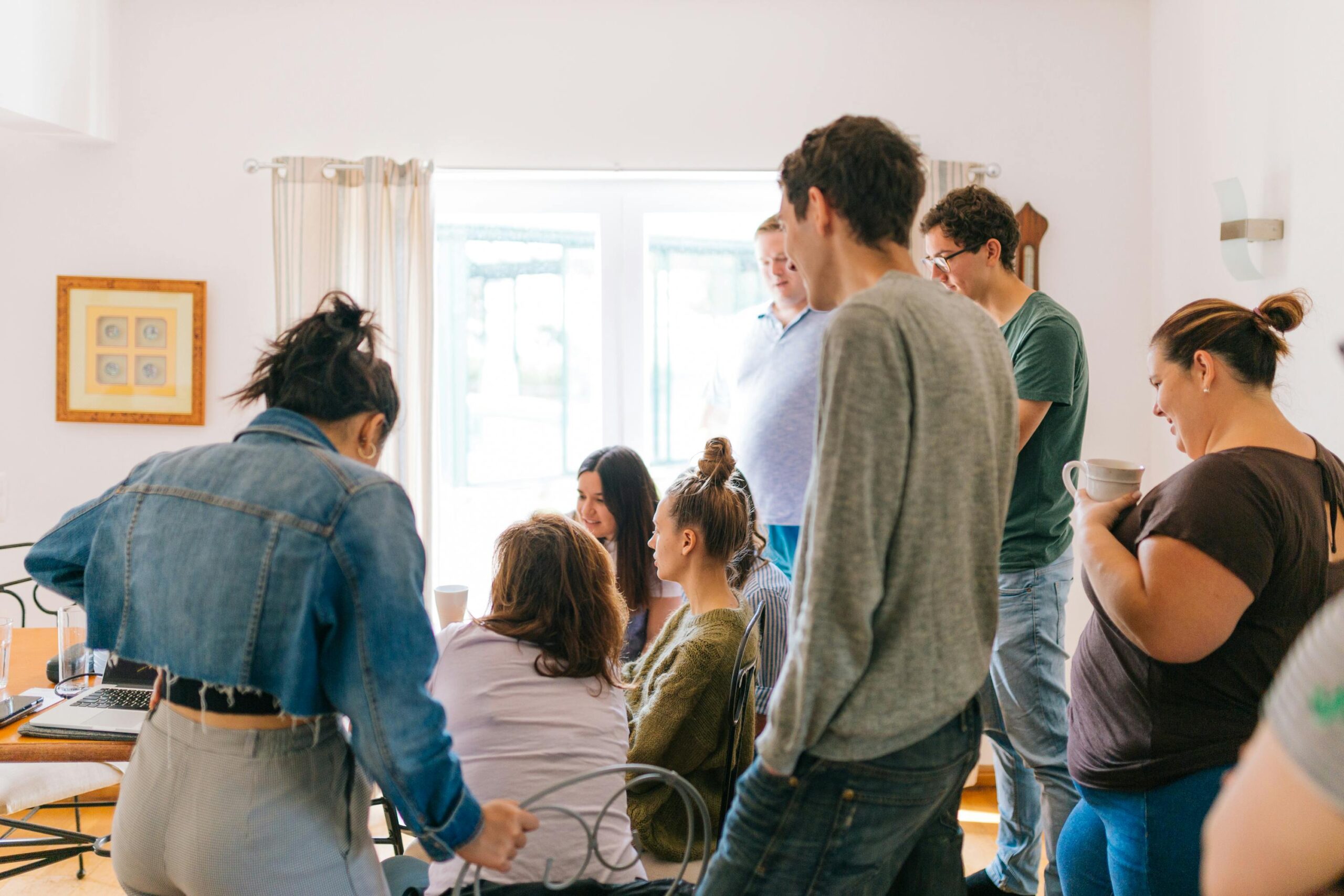 A group of adults collaborating around a table in a bright room, promoting teamwork and creativity.